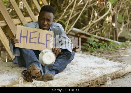 Portrait of young homeless African man in the streets outdoors Stock Photo
