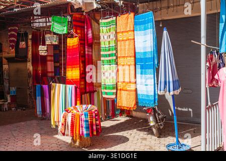Colourful brightly coloured fabrics hanging on display outside a shop in the Souk des Teinturiers (Dyer’s Souk), Medina quarter in Marrakesh, Morocco Stock Photo