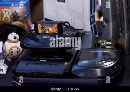 Sega Genesis with Sega CD and 32X add‑ons, featuring a DOOM cartridge inserted, displayed in a retro gaming setup with classic hardware and collectibl Stock Photo