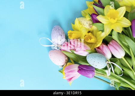 Tulips and daffodils flowers over brigh blue background Stock Photo