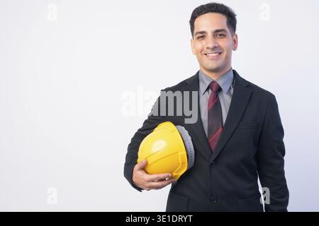 Studio shot of handsome Persian businessman in suit as engineer with hardhat isolated against white background Stock Photo
