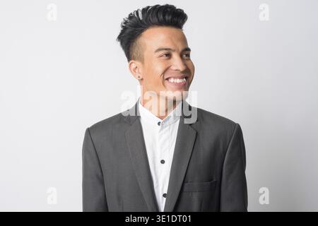 Studio shot of young Asian businessman in suit against white background Stock Photo