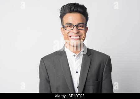 Studio shot of young Asian businessman in suit wearing eyeglasses against white background Stock Photo
