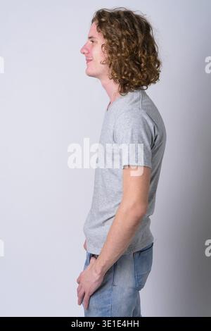 Studio shot of young handsome man with long curly hair against white background Stock Photo