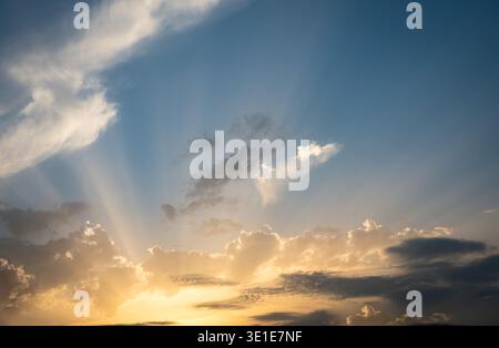A dramatic sunset sky filled with vivid orange and gold cloud formations over the Mediterranean coast of Tunisia, North Africa. Stock Photo