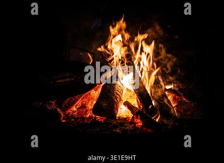 A large bonfire blazes against the dark Arctic night sky in a snow-covered wilderness near Tromsø, northern Norway. Stock Photo