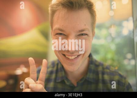 Portrait of young handsome tourist man exploring Ho Chi Minh city in Vietnam Stock Photo