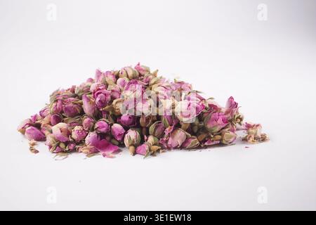 Dried pink rose buds on a white surface Stock Photo
