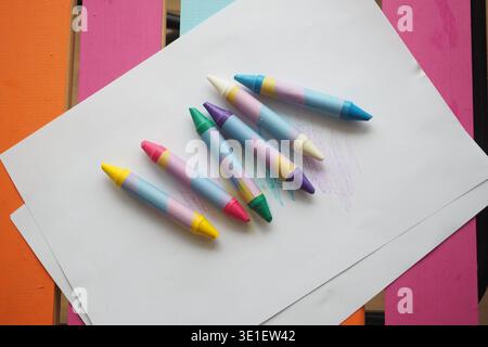 Colorful crayons on paper in a creative workspace Stock Photo