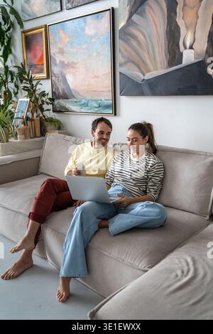 Married couple happy husband and wife enjoying spending time talking together relaxing on sofa. Stock Photo