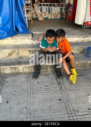 Mexican kids with a mobile phone, Merida Mexico Stock Photo