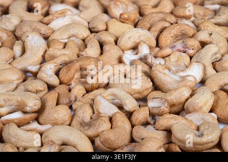 Cashews in bowl. Cashew nuts served in shallow dish with cozy lighting. Social setting featuring warm lighting and delightful bowl of cashew nuts Stock Photo