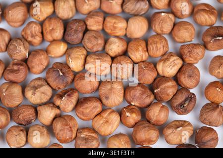 Topview hazelnut kernels arranged in loose pile, natural matte skins and varied tones create organic pattern, evokes farmhouse pantry or chocolatier m Stock Photo