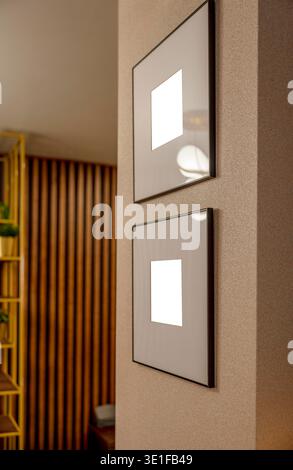 two blank picture frames on textured wall in modern apartment interior vertical composition with minimal wall decor and empty poster mockup space for Stock Photo