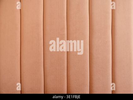 textured upholstered wall panel background with vertical soft fabric lines in modern hotel bedroom interior decorative padded headboard, textile surfa Stock Photo