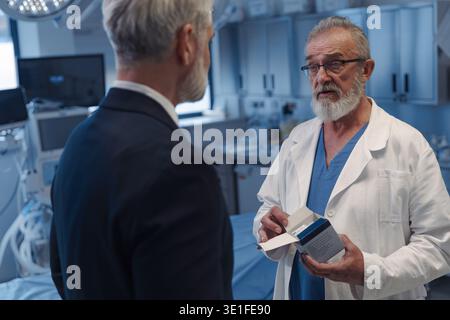 Medical sales representative presenting new medication to doctor. Stock Photo