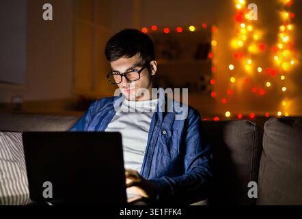 Man with laptop working late on christmas night Stock Photo