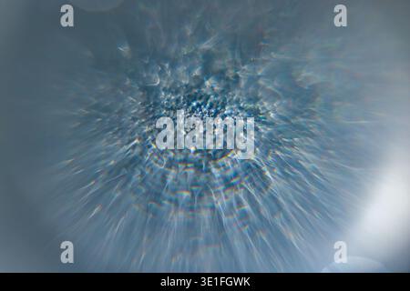 Dynamic abstract blue background with radiant light burst, shimmering texture, and soft sparkling highlights. Ideal for futuristic design, technology Stock Photo