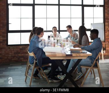 Coworkers working together on laptops and paper documents Stock Photo