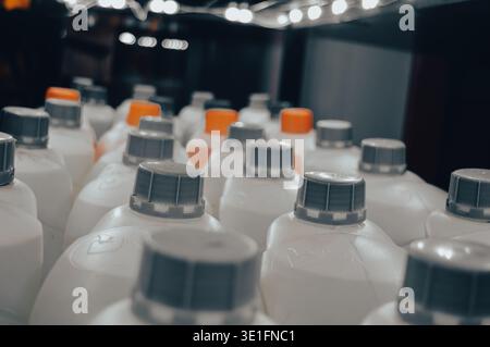 there are a lot of white cans with non-freezing liquid or other chemicals . grey and orange caps on cans. High quality photo Stock Photo