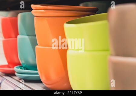 colorful plastic flower pots stand in a row on a shelf. High quality photo Stock Photo