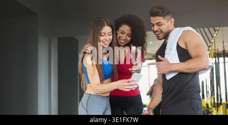 Young friends in sportswear relax after training with smartphone Stock Photo