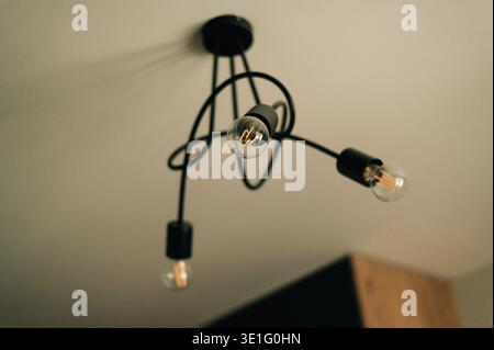 Minimalist interior with white walls and a modern, black spider chandelier Stock Photo