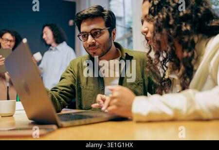 designers analyze prototype together, team members examine prototype details with notes and planning energy Stock Photo