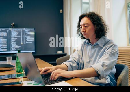 Focused Coder Working, An Attentive Software Engineer Working Diligently In Sleek Office Bathed In Sunlight Stock Photo