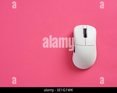 White modern computer mouse resting on a bright pink background, representing technology, computing, and digital work Stock Photo
