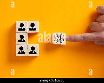 Hand pushing an AI chip icon block towards a group of human symbol blocks, symbolizing artificial intelligence integrating with human workers Stock Photo
