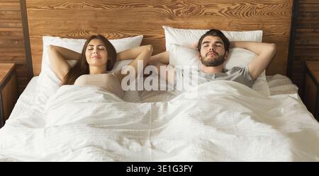 Couple Relaxing in Bed During Morning Time in a Cozy Bedroom Setting Stock Photo