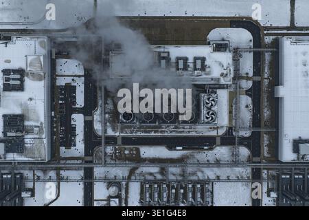 Aerial view of modern data center infrastructure, with cooling towers emitting steam, surrounded by snow in winter, Eemshaven, Netherlands. Stock Photo