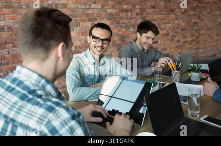 Programmers cooperating at IT company developing apps Stock Photo