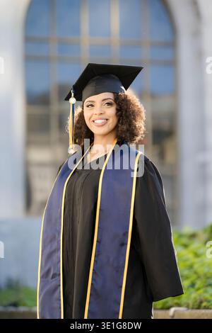 Smiling Berkeley Graduate in Cap and Gown on Campus Stock Photo