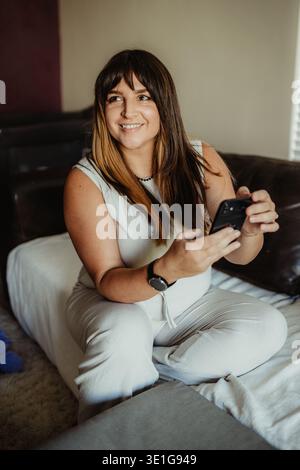 Woman working remotely from home on her phone Stock Photo