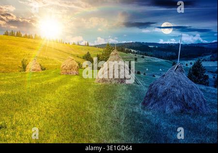 wonderful haystacks in a row on grassy hay field. day meet night. sun and moon over beautiful rural scenery with pasture in summer. traditional agricu Stock Photo