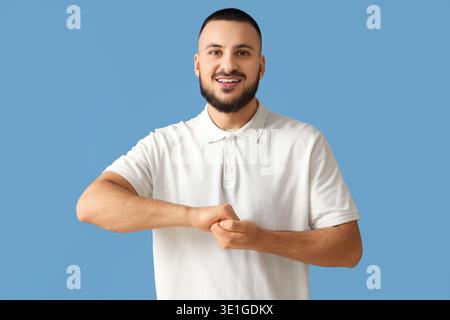Handsome man using sign language on blue background Stock Photo