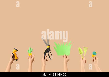 Female hands with gardening tools on beige background Stock Photo