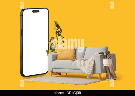 Comfortable sofa and mobile phone with blank screen on yellow background Stock Photo