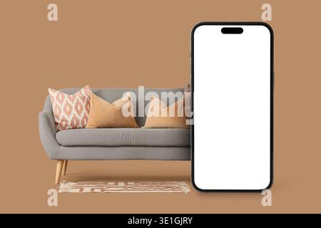 Comfortable sofa and mobile phone with blank screen on brown background Stock Photo
