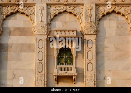 A close-up of a decorative marble window with green wooden shutters on the exterior wall of the Jaswant Thada cenotaph in Jodhpur. Stock Photo