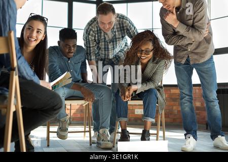 Creative people looking at project plan on floor Stock Photo