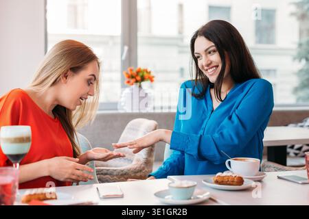 Delightful bride showing wedding ring to friend Stock Photo