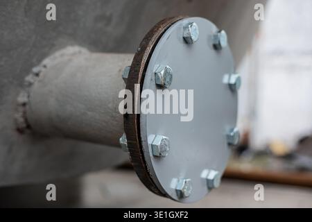 flange plug on metal barrel. A round bolted plug covers the pipe from the. High quality photo Stock Photo