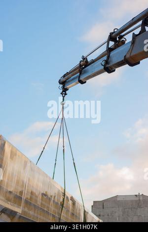 Cargo sandwich panels hanging in the air on crane boom bottom view. High quality photo Stock Photo