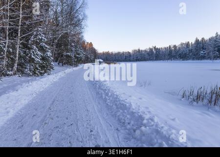 Curved snowy road in cold winter countryside landscape Stock Photo