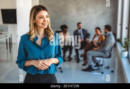 Young happy successful business woman working in corporate office Stock Photo