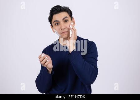 Young man thinking and touching his face with hand Stock Photo
