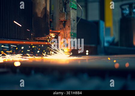 A beautiful bright moment of cutting a sheet of metal with a laser releasing sparks. Automatic Programmed Laser Metal Cutting Machine. High quality ph Stock Photo